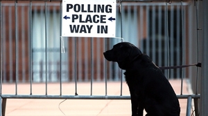 A dog is tied to railings at a polling station in Glasgow, Scotland