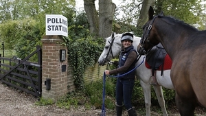 An equestrian groom arrives at a polling station in Bramshill, southern England