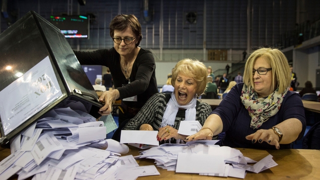 Election officials react as they are given ballot papers ready to be counted at the Emirates Arena in Glasgow