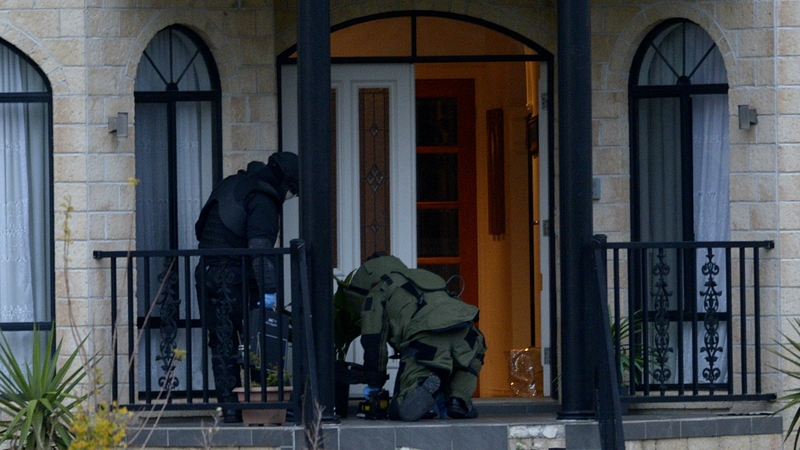 Officers wearing bomb suits at a home in Greenvale, Melbourne, one of several houses raided