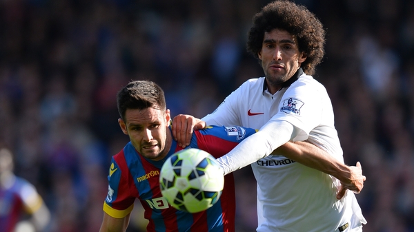 Scott Dann tries to hold off Manchester United midfielder Marouane Fellaini