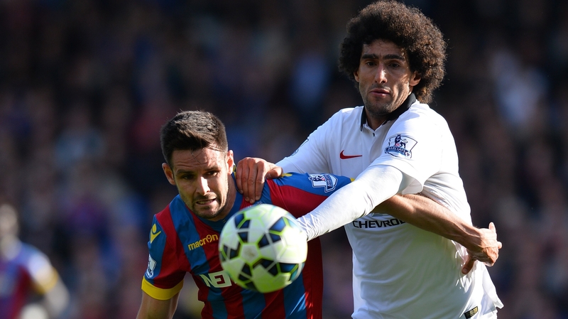 Scott Dann tries to hold off Manchester United midfielder Marouane Fellaini