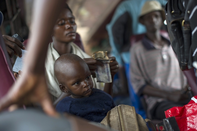 A mother and her child sit on a bus leaving Bujumbura