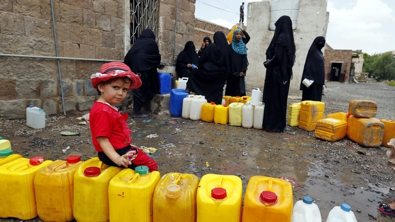 People wait to fill water cans from a clean source