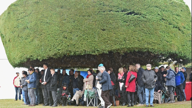 Crowds shelter under a tree during the Grand Annual Day at Warrnambool Racing Club, Australia