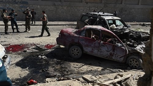 Afghan and foreign security forces inspect the site of the suicide attack in Kabul