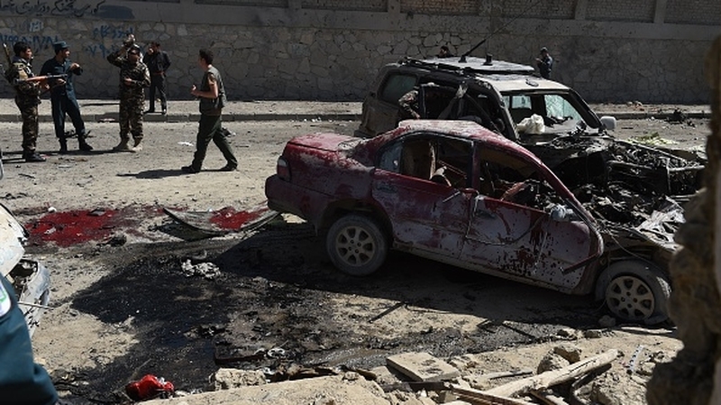 Afghan and foreign security forces inspect the site of the suicide attack in Kabul