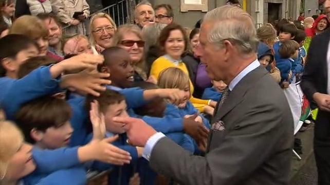 The Prince of Wales shakes hands with some local schoolchildren