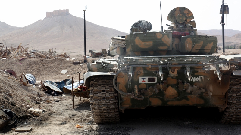 A Syrian armoured tank takes up position during fighting against IS in Palmyra