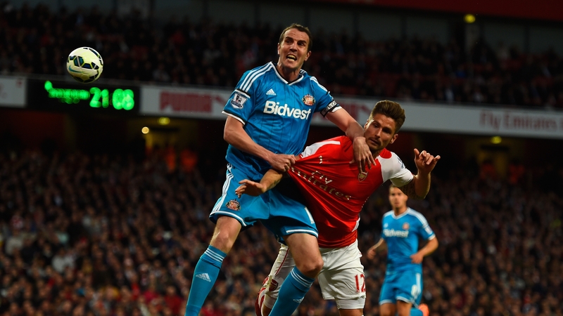 John O'Shea of Sunderland and Olivier Giroud of Arsenal tussle for the ball
