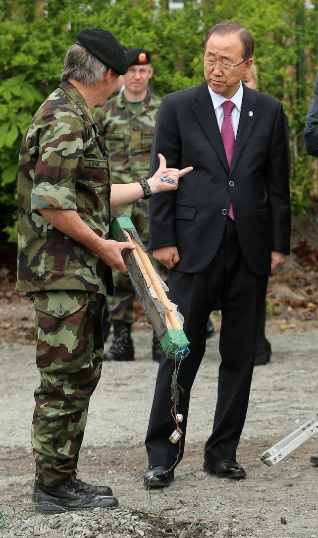 Lieutenant Colonel Ray Lane shows Mr Ban the pressure plate of a bomb