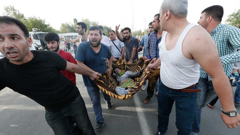 People help wounded victims after an explosion during a election campaign rally of the HDP in Diyarbakir