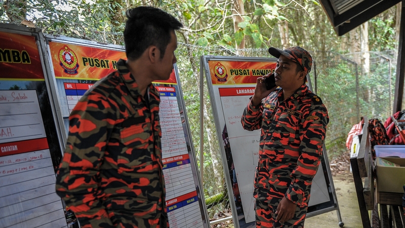 Malaysian rescue team members wait for victims to be evacuated