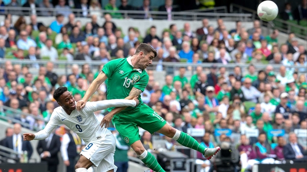 Robbie Brady wins an ariel battle with Raheem Sterling