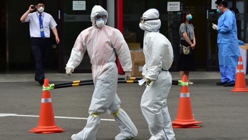 Medical workers in full protective gear walk past in front of the emergency section at the Samsung Medical Centre