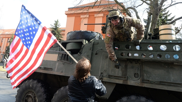 A US soldier talks to a boy holding a US national flag as a US military convoy arrives at a Czech army barracks in March