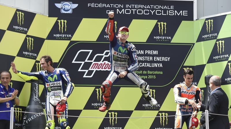 Jorge Lorenzo (C) leaps onto the podium after winning the Grand Prix de Catalunya in Barcelona