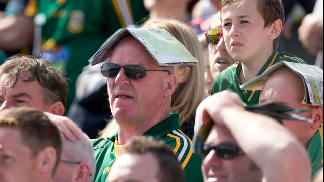 A Meath fan uses an unshredded programme to shelter from the sun in Navan