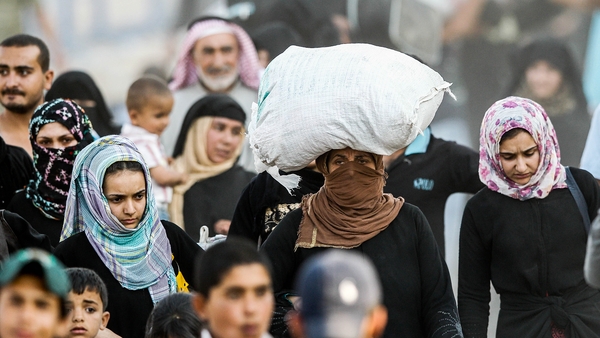 Syrian refugees walk to cross into Turkey at Akcakale border gate