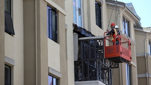 Workers inspect the balcony that collapsed overnight