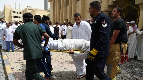Medical staff carry a man on a stretcher at the site of the attack in Kuwait
