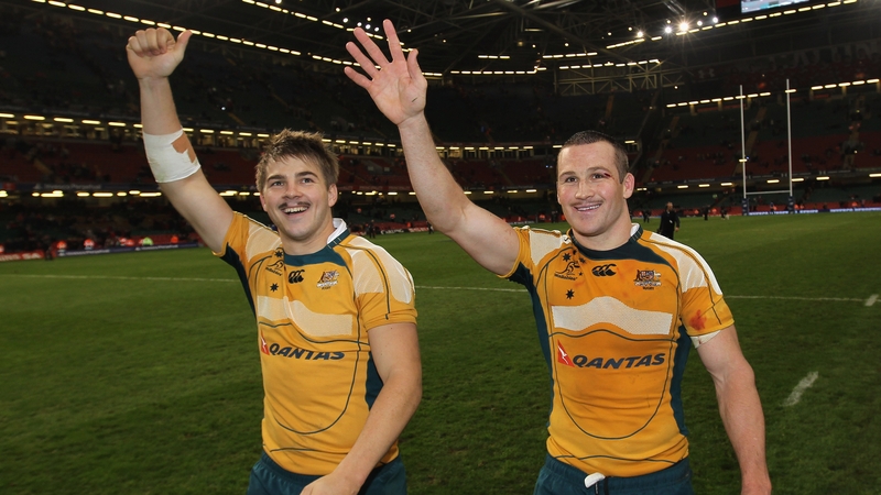 Drew Mitchell (L) and Matt Giteau (R) wave to Australian fans following a game in 2009