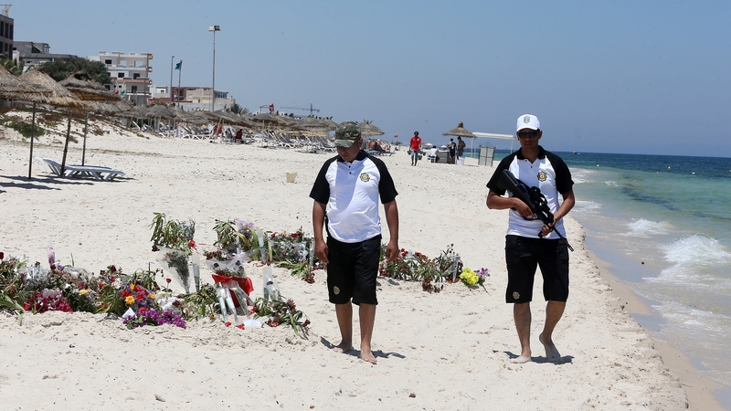 Póilíní na Túinéise ag patrólú an trá ar a maraíodh 38 turasóir an Aoine seo caite.