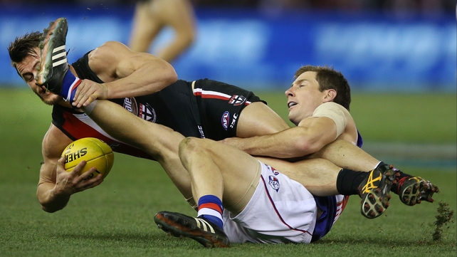 Maverick Weller of the Saints is tackled by Dale Morris of the Bulldogs during an AFL match at Etihad Stadium in Melbourne, Australia