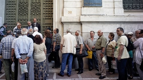 Pensioners line up outside a National Bank branch in Athens