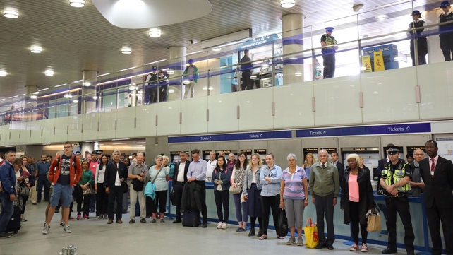 People pause for a minute's silence at Kings Cross Underground station in London