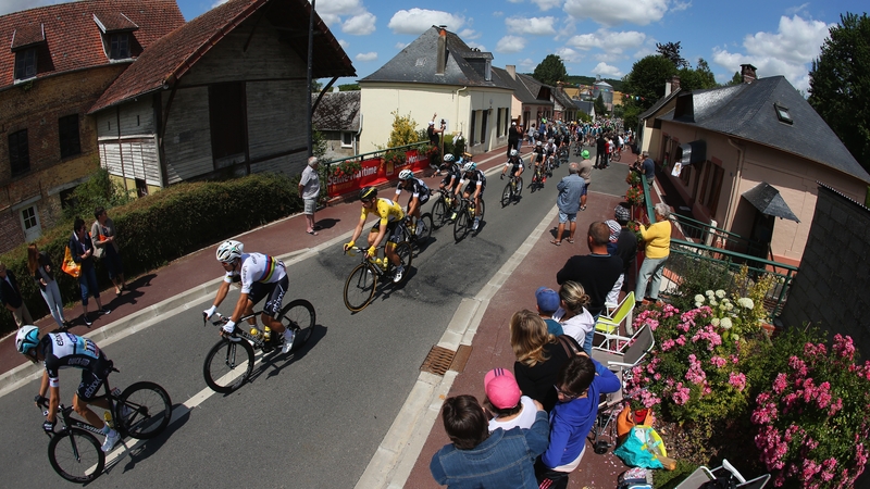 Yellow jeresey wearer Tony Martin of Germany and Etixx-Quick Step (3L) rides with the peloton as they are cheered on by spectators during stage six