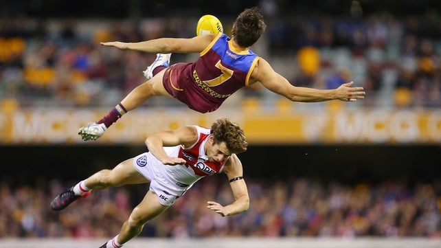 Jed Adcock of the Lions and Nick Smith of the Swans collide during the round 15 AFL match between the Brisbane Lions and the Sydney Swans at The Gabba