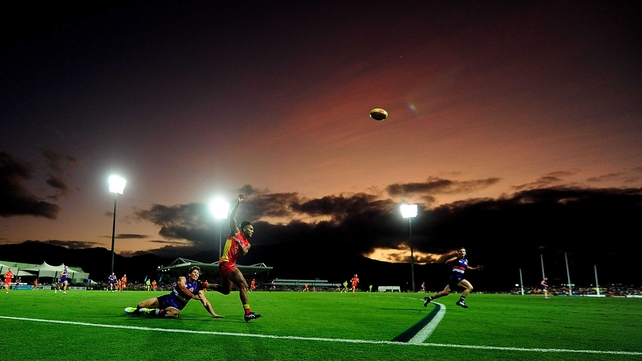 Aaron Hall of the Suns gets a kick away despite the tackle of Will Minson of the Bulldogs during the round 15 AFL match between the Western Bulldogs and the Gold Coast Suns at Cazaly's Stadium