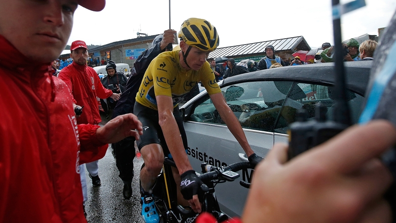 Chris Froome is escorted by security after defending the yellow jersey on stage 12