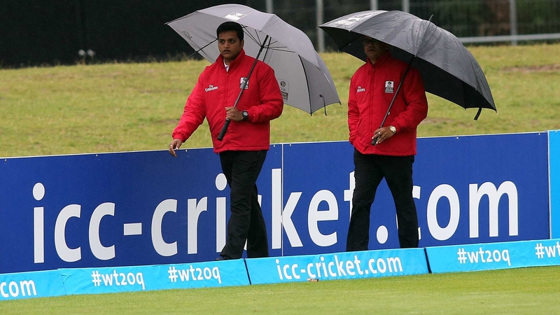 The umpires inspect the rain-soaked outfield at Malahide