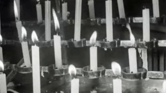 People praying and lighting candles in a vigil for peace at St. Eugene's Cathedral, Derry.