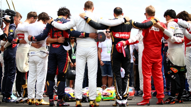 Jules Bianchi's brother Tom Bianchi and sister Melanie Bianchi observe a minute's silence with their father Philippe Bianchi, mother Christine Bianchi and Formula One drivers as they form a huddle around the drivers' helmets