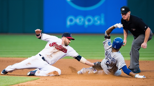 Jason Kipnis of the Cleveland Indians tries to tag Alcides Escobar of the Kansas City Royals on a hit to left