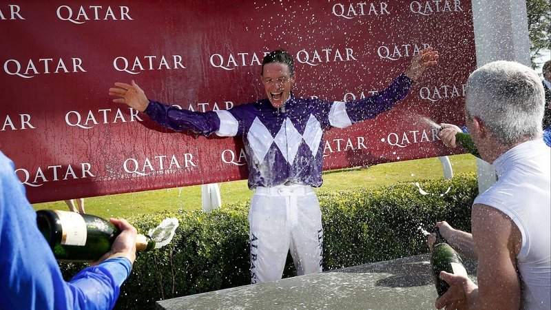 Richard Hughes' weighing room colleagues soak the retiring rider with champagne at Goodwood