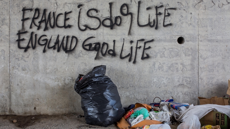 Graffitti reading 'France is dog life, England is good life' is scrawled on a wall