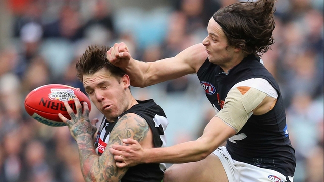 Dane Swan of the Collingwood Magpies reacts to a heavy challenge by Dylan Buckley of the Carlton Blues at the MCG