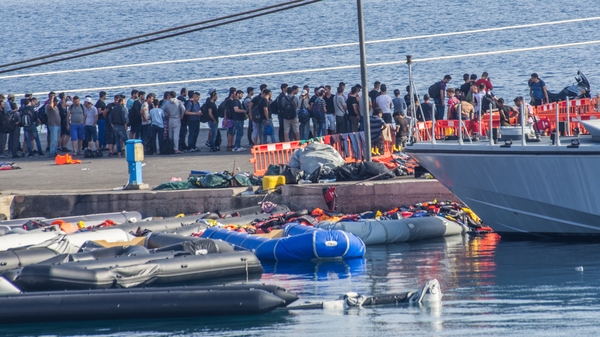 Syrian refugees wait to board a Greek cruise liner, converted into a refugee processing ship