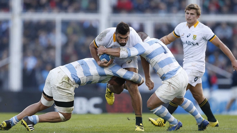 South Africa's Damian de Allende resists a tackle by Benjamin Macome and Santiago Garcia Botta of Argentina