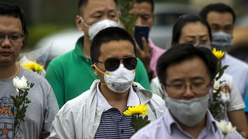 Residents hold flowers at a vigil for the victims of the explosions