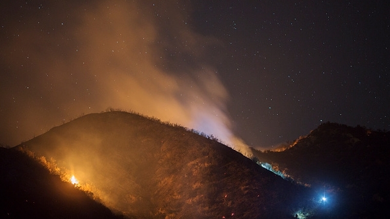 Firefighters wearing headlamps climb to try to extinguish wildfires in the Angeles National Forest, California