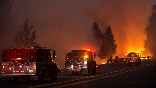 Fire engines back up firefighters near the town of Pollock Pines, California