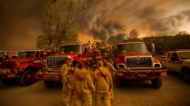 Firefighters confer as a fire burns near Clearlake, California