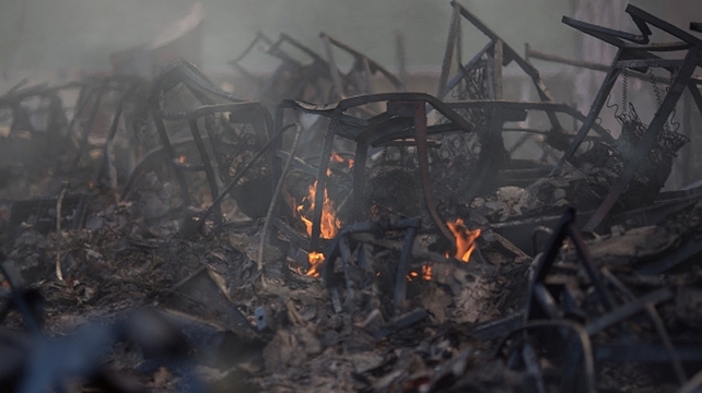 The ruins of a burned building smolder at the Warm Springs Rehabilitation Center
