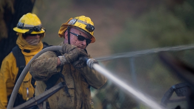 Firefighters work to extinguish a wildfire at the Warm Springs Rehabilitation Center