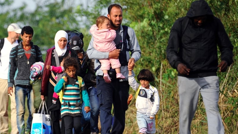 Migrant families walk between rails near the border village Roszke, at the Hungarian-Serbian border